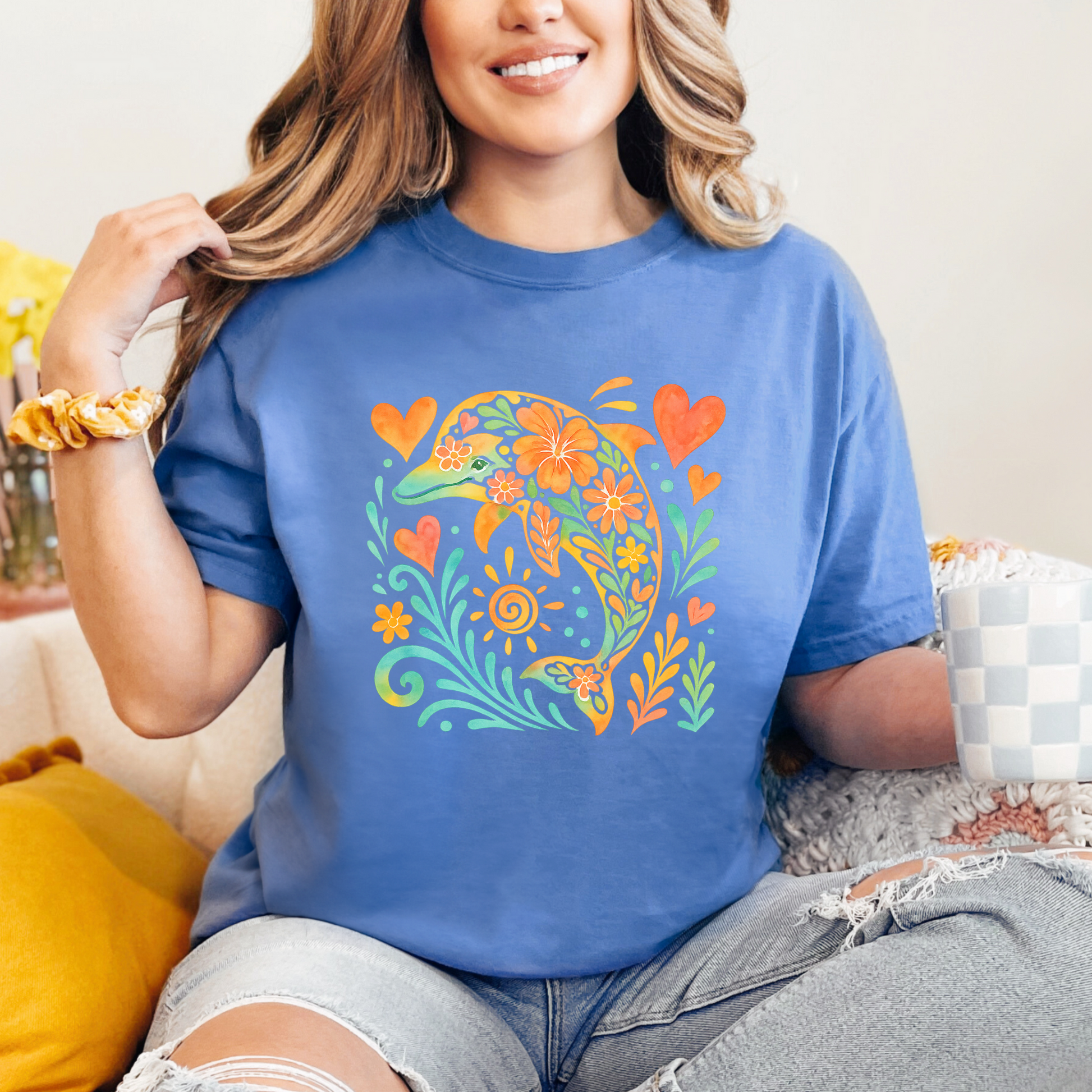 Woman wearing a blue graphic t-shirt with a colorful dolphin design.